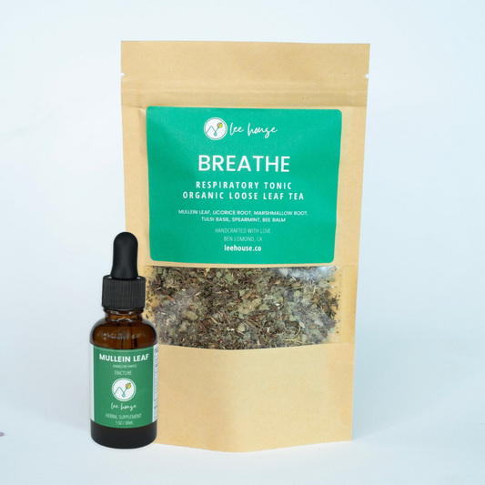 A packaged product labeled 'BREATHE Respiratory Tonic Organic Loose Leaf Tea' with a small clear bottle in front containing a liquid herbal extract.