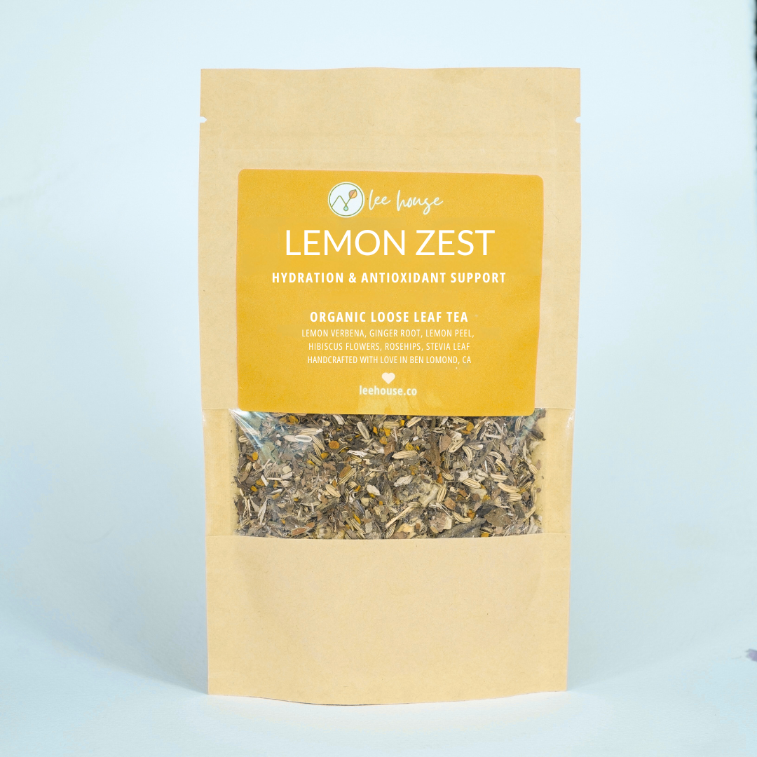 Bag of organic loose leaf tea labeled 'Lemon Zest' on a light blue background