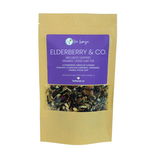A stand-up kraft paper pouch of Lee Lows Elderberry & Co. wellness support organic loose leaf tea, featuring a prominent purple label and a clear window showing the loose leaf blend inside.