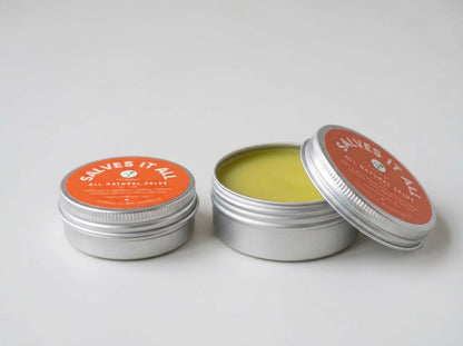Two small round silver metal tins of Salves It All All Natural Salve on a light gray background, with one tin open to show the yellow-green salve inside and the other closed with an orange label.