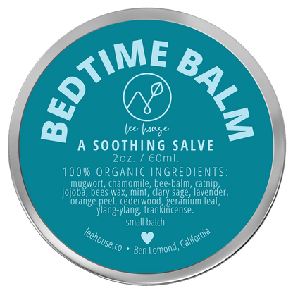photograph of Bedtme Balm - photo contains a tin of slave with a bright blue label that reads: Bedtime Balm - all natural soothing salve. 100% organic: mugwort, chamomile, bee balm, catnip, jojoba, clary sage, mint, lavendar, orage peel, cedarwood, geranium leaf, ylnag ylang, frankincense, external use only. handcrafted sith love. leehouse.co