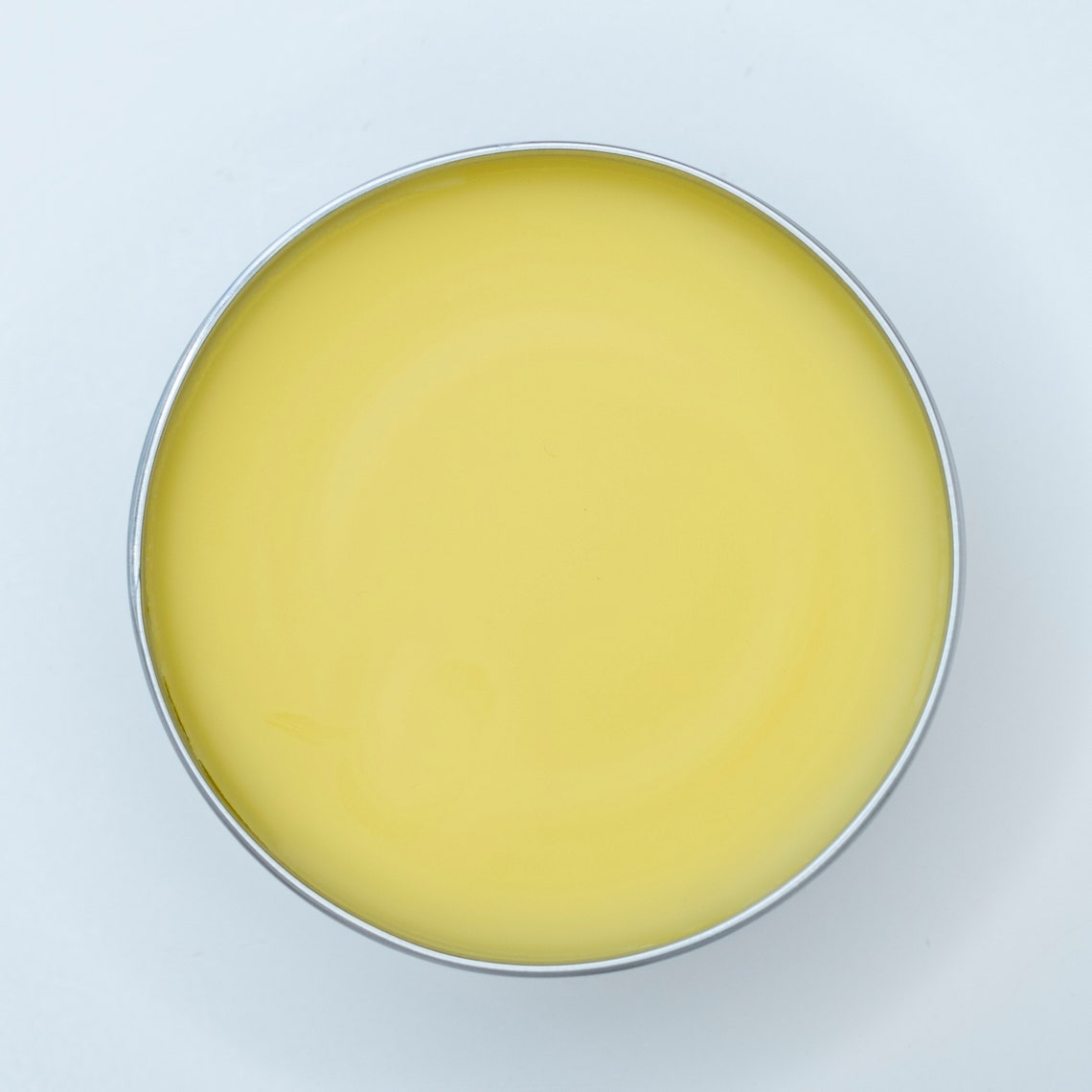  Interior image of a tin of Pet Salve - All-Purpose healing salve for cats & dogs. 100% organic, lickable, pet-safe ingredients. The salve is a cream color from the beeswax and calendula oil.